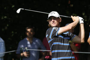 Professional Golfer Emiliano Grillo Analyzing His Shot On The Golf Course Wallpaper