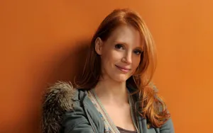 Radiant Jessica Chastain Posing In An Elegant Green Dress Wallpaper