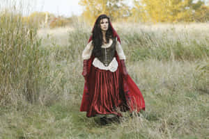 Red Cloaked Womanin Autumn Field Wallpaper