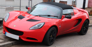 Red Lotus Elise Car Parked On Curb Wallpaper