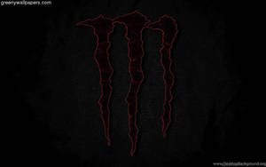 Red Monster Logo Illuminated On Dark Screen Wallpaper