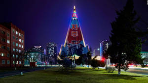 Ryugyong Hotel Illuminated At Night In Pyongyang, North Korea Wallpaper