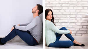 Sad Couple Sitting On Floor Wallpaper