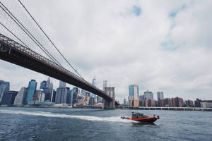 Sailing Speed Boat Passing Beneath A Bridge Wallpaper