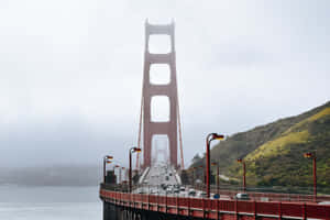 San Francisco’s Iconic Fog Rolling Over The Bay Bridge. Wallpaper