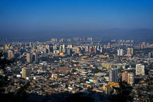 Santiago's Majestic Skyline Under A Blue Hazy Sky Wallpaper