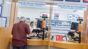 Senior Man Making Purchase At Pharmacy Wallpaper
