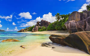 Serene Beach Landscape With Majestic Rock Formations Wallpaper