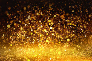 Shimmering Golden Glitters On A Dark Background Wallpaper