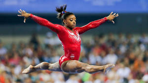 Simone Biles Powerful Split Jump Wallpaper