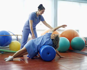 Skilled Therapist Guiding Patient In Physical Therapy Wallpaper