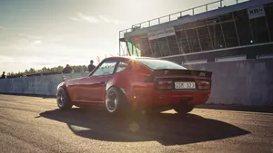 Sleek Datsun In A Picturesque Landscape Wallpaper