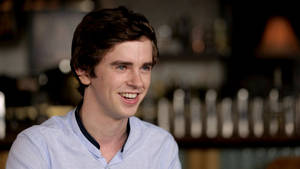 Smiling Freddie Highmore Focus Shot Wallpaper