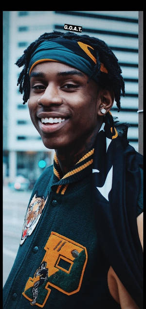 Smiling Polo G In Varsity Jacket Wallpaper