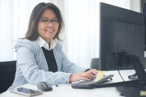 Smiling Professional Secretary At Work Wallpaper