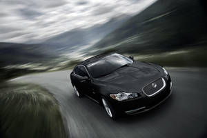Speed And Style Combine In This Sleek Black Jaguar Car. Wallpaper
