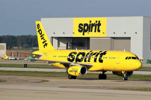 Spirit Airlines' Bright Yellow Airplane Preparing For Takeoff Wallpaper