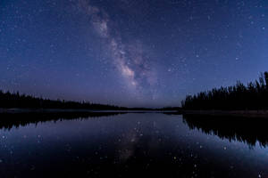 Starry Night Sky Over A River Wallpaper