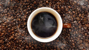 Steaming Coffee Cup Over Beans.jpg Wallpaper