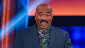 Steve Harvey Smiling In A Colorful Shirt Wallpaper