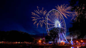 Stunning View Of Illuminated Ferris Wheel In Monterrey At Dusk Wallpaper