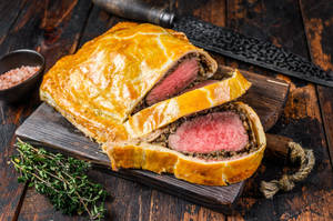 Succulent Beef Wellington On A Chopping Board Wallpaper