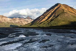 Sunlit_ Mountain_ Ridge_and_ Riverbed_ Alaska Wallpaper