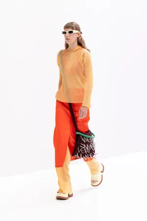 Sunnei Model With Orange-toned Outfit Wallpaper