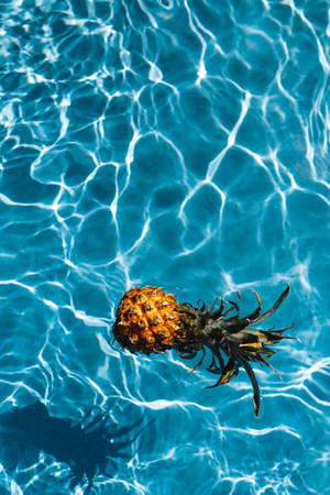 Take A Dive Into Relaxation With This Pineapple In The Pool. Wallpaper