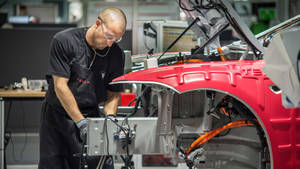 Technician Assembling Car Tesla Factory Wallpaper