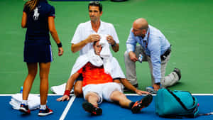 Tennis Player Medical Assistance During Match Wallpaper