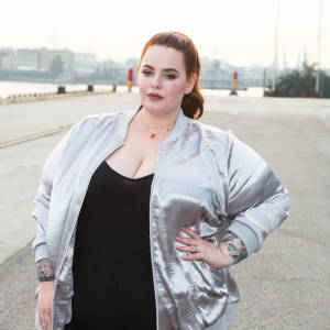 Tess Holliday Radiating Positivity In Silver Jacket Wallpaper