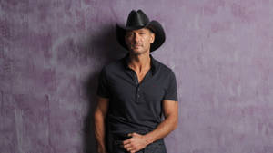 Tim Mcgraw Standing Against Limewash Wall Wallpaper