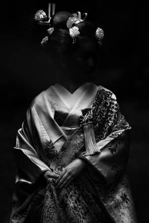 Traditional Japanese Geisha In A Dark Setting Wallpaper