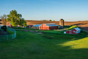 Tranquil Countryside Farm With Numerous Structures Wallpaper