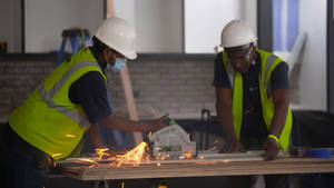 Two Construction Workers Helping Each Other Wallpaper