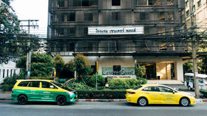 Two Different Taxi In Front Of Hotel Wallpaper