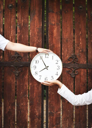 Two Hands Holding A Clock Wallpaper