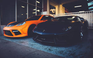 Two Lamborghinis Orange And Black Wallpaper