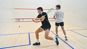 Two Men Looking At Squash Ball Wallpaper