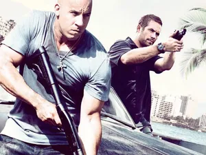 Two Men Standing Next To A Car With Guns Wallpaper