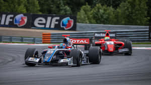 Two Racing Cars On A Track With A Sign Wallpaper