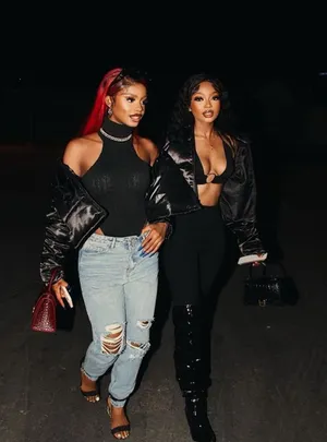 Two Women Walking Down The Street At Night Wallpaper