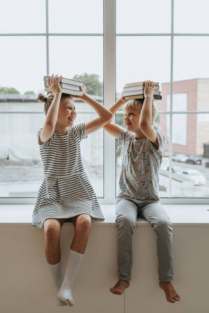 Two Young Kids Engrossed In Study Wallpaper