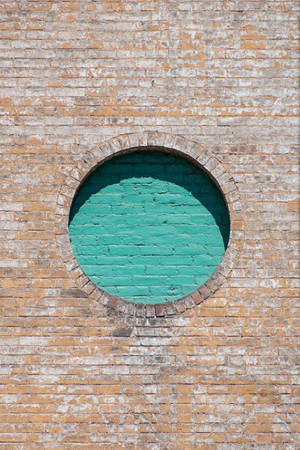 Unveiling Possibilities: A Hole In A Weathered Brick Wall Wallpaper