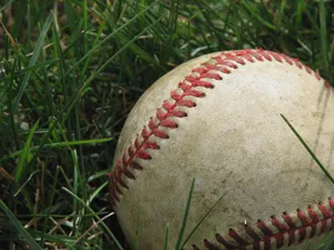 Used Dirty Baseball On Grass Wallpaper