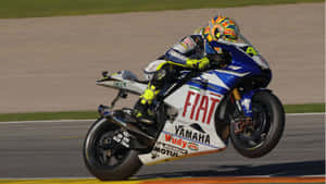 Valentino Rossi (vr46) Dominating The Racetrack Wallpaper