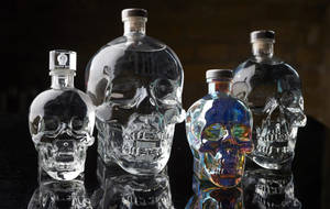 Varying Sizes Of Crystal Head Vodka Bottles Against An Elegant Backdrop Wallpaper