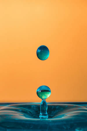 Vibrant 4k Iphone Wallpaper Featuring A Dynamic Blend Of Orange And Blue Liquid Hues. Wallpaper