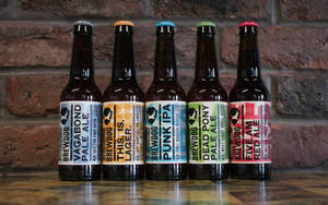 Vibrant Array Of Brewdog Craft Beer Bottles Against A Brick Wall Wallpaper